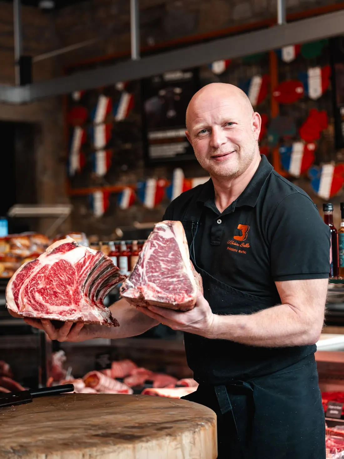 Frédéric Bello tient deux côtes de bœuf maturées dans sa boutique
